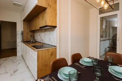 a dining room with a table and a kitchen at Bright, Newly Renovated Condo Near Danube River in Belgrade