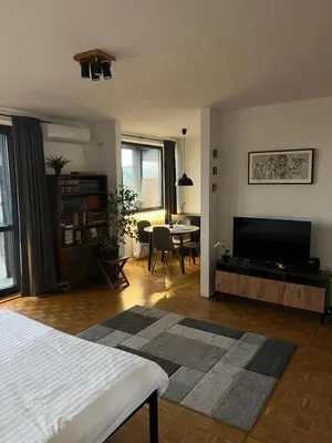 a living room with a bed and a flat screen tv at Oasis Residences A in Belgrade
