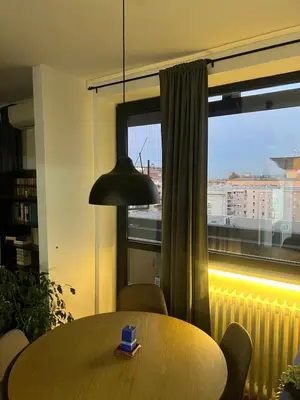a table and chairs in a room with a window at Oasis Residences A in Belgrade