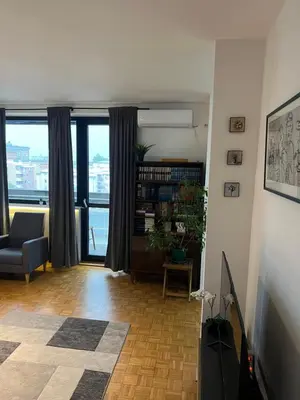 a living room with a couch and a book shelf at Oasis Residences A in Belgrade