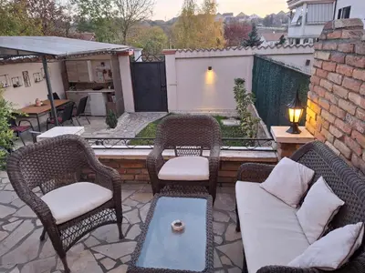 a patio with wicker chairs and a couch at Vila Tara in Belgrade