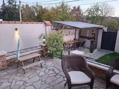 a patio with chairs and a table and a kitchen at Vila Tara in Belgrade