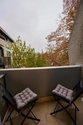 two chairs on a balcony with a view of trees at Best choice Hram centar in Belgrade