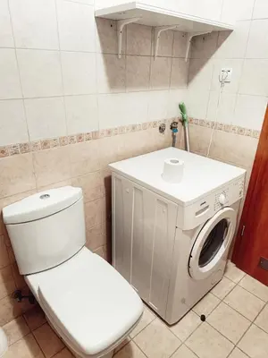 a bathroom with a toilet and a washing machine at Apartman Đul in Mladenovac