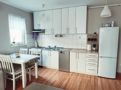 a kitchen with a table and a white refrigerator at Apartman Đul in Mladenovac