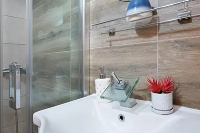a bathroom with a white sink and a shower at Biser 17 in Zemun