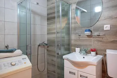 a bathroom with a shower and a sink and a mirror at Biser 17 in Zemun