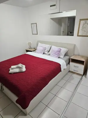 a bedroom with a large bed with a red blanket at Atina in Žarkovo