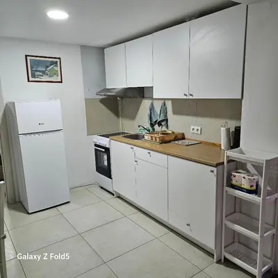 a kitchen with white cabinets and a refrigerator at Atina in Žarkovo