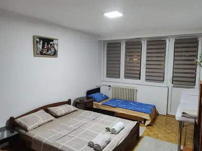 a small bedroom with two beds and a window at Relax apartman bg in Belgrade