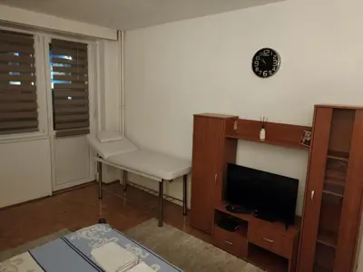 a living room with a tv and a table and a chair at Relax apartman bg in Belgrade