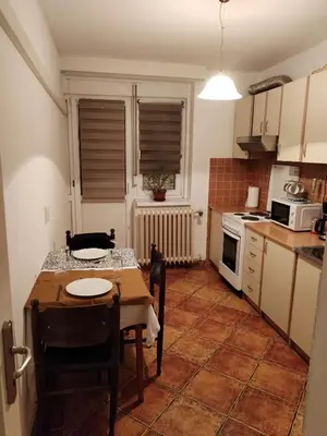 a kitchen with a table and chairs and a kitchen with a stove at Relax apartman bg in Belgrade