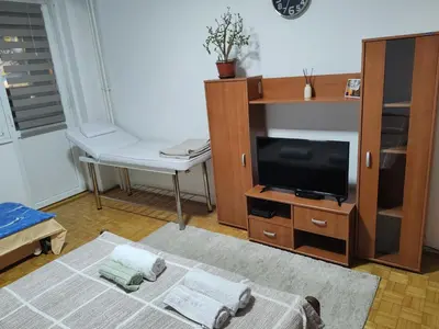 a living room with a tv and a table at Relax apartman bg in Belgrade