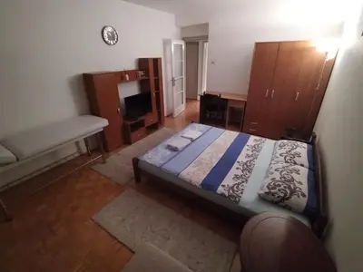 a bedroom with a bed and wooden furniture and a couch at Relax apartman bg in Belgrade