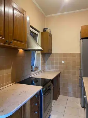 a kitchen with wooden cabinets and a stove top oven at Grand Residency Luksuzan stan u centru grada in Belgrade