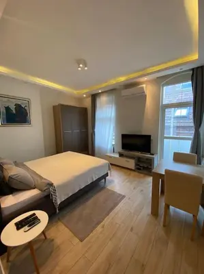 a bedroom with a bed and a couch and a tv at Grand Residency Luksuzan stan u centru grada in Belgrade
