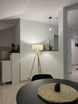 a dining room with a table and a lamp at Apartman Cristal LUX in Surčin