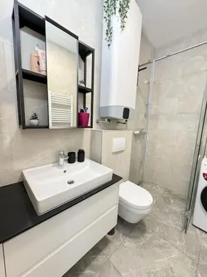 a white bathroom with a sink and a toilet at West 65 airport city apartment in Belgrade