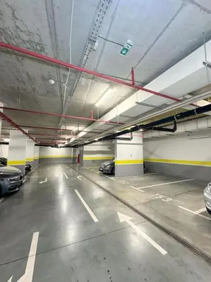 an empty parking garage with cars parked in it at West 65 airport city apartment in Belgrade