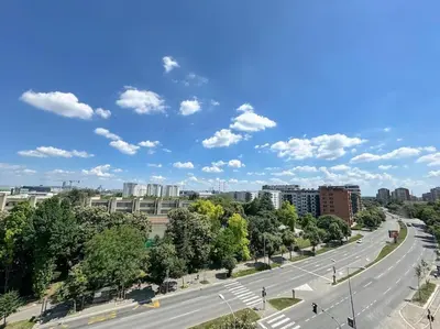 an empty road in a city with trees and buildings at West 65 airport city apartment in Belgrade