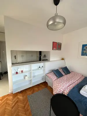 a bedroom with two beds and a table and a lamp at Maxim in Pančevo