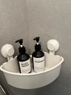 a white holder with two bottles of soap and shampoo at Maxim in Pančevo