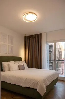 a bedroom with a large bed and a large window at Designer flat with character in Belgrade