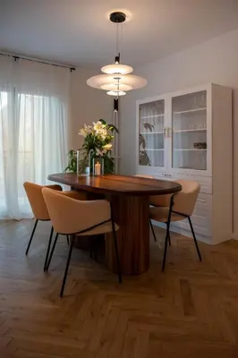 a dining room table with chairs and a vase of flowers at Designer flat with character in Belgrade