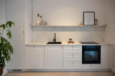 a white kitchen with a sink and a stove at Designer flat with character in Belgrade