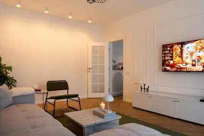 a living room with a couch and a tv on a wall at Designer flat with character in Belgrade