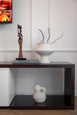 a table with two sculptures and a vase on it at Designer flat with character in Belgrade