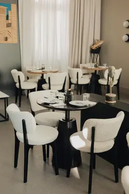a dining room with tables and white chairs at Hotel Flaneur in Belgrade