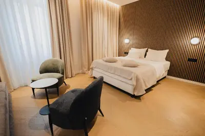 a hotel room with a bed and two chairs at Hotel Flaneur in Belgrade