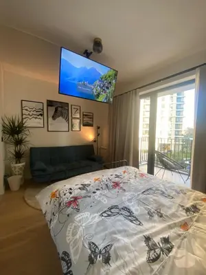 a bedroom with a bed and a flat screen tv at Waterfront Retreat with Garage and Balcony in Belgrade