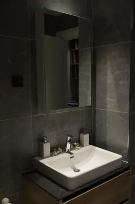 a bathroom with a white sink and a mirror at Waterfront Retreat with Garage and Balcony in Belgrade