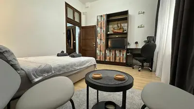 a bedroom with a bed and a table and chairs at Sunset apartment in Belgrade