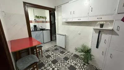 a kitchen with white cabinets and a black and white floor at Sunset apartment in Belgrade