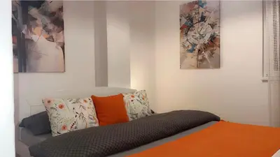 a room with a couch with pillows and paintings at NEW BELGRADE Lovely three bedroom apartment in Belgrade