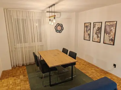 a dining room with a wooden table and chairs at NEW BELGRADE Lovely three bedroom apartment in Belgrade
