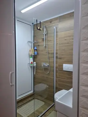 a bathroom with a glass shower with a toilet at Wood Studio in Belgrade