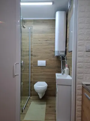 a bathroom with a toilet and a glass shower at Wood Studio in Belgrade