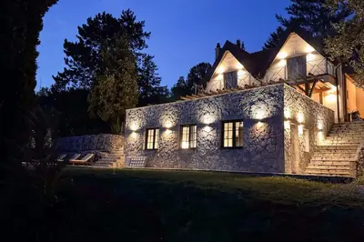 a stone house with lights on it at night at Serenity hill in Draževac