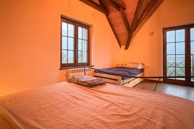 a bedroom with a large bed in a room with windows at Serenity hill in Draževac