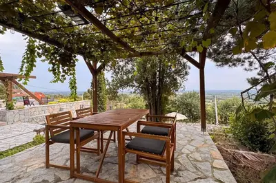 a wooden table and chairs on a stone patio at Serenity hill in Draževac