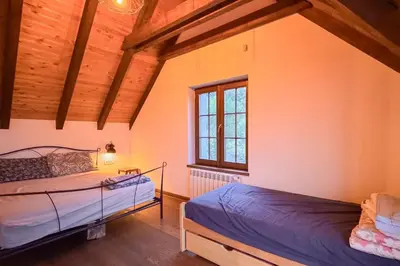 two beds in a room with wooden ceilings at Serenity hill in Draževac