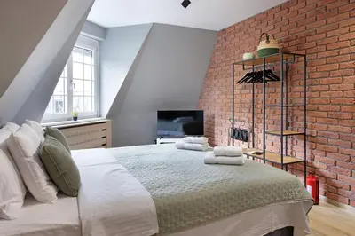 a bedroom with a large bed with a brick wall at Apartman Paradise Slavija Dos in Belgrade