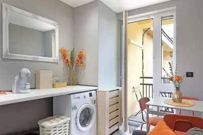 a laundry room with a washing machine and a table at Apartman Paradise Slavija Dos in Belgrade