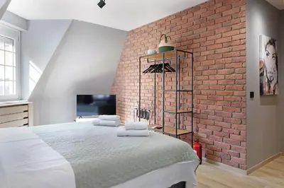 a bedroom with a brick wall and a large bed at Apartman Paradise Slavija Dos in Belgrade