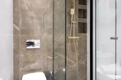 a shower with a glass door next to a toilet at Apartman Paradise Slavija Dos in Belgrade