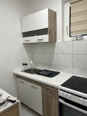 a white kitchen with a sink and a stove at Aurora Apartmani Indjija in Inđija